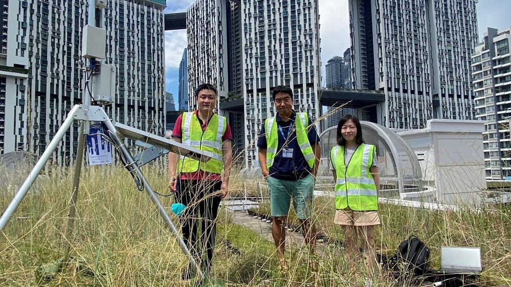 Asst Prof Yuan (centre) together with his research team setting up a weather station atop the roof of a building at the Tanjong Pagar area in 2022.