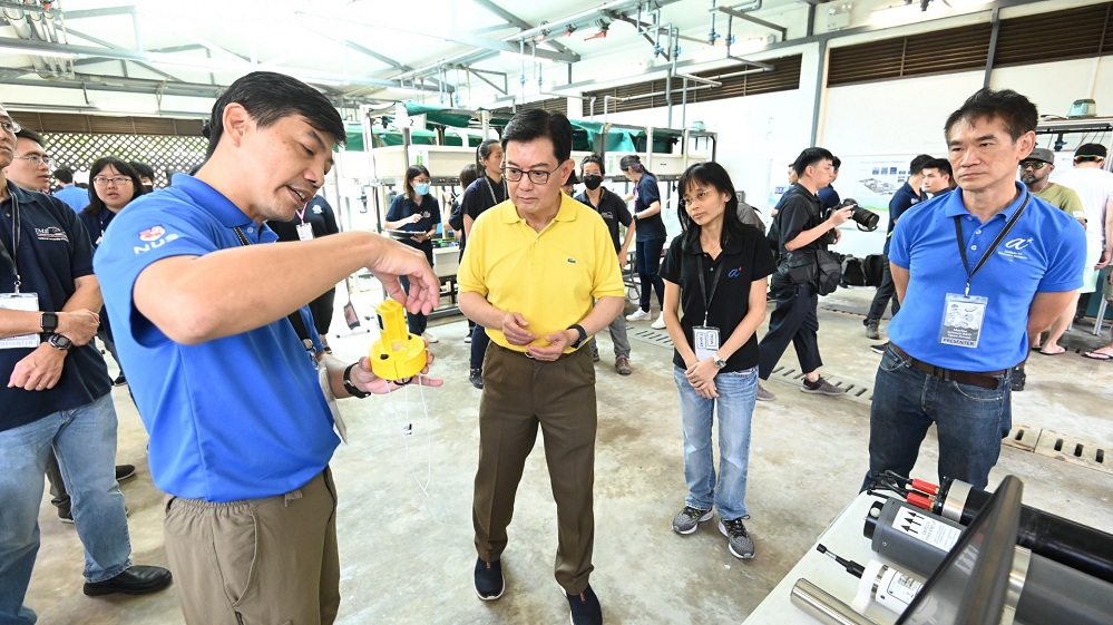 Mr Koay Teong Beng (extreme left), Senior Engineer at NUS Tropical Marine Science Institute (TMSI), accompanied by Ms Ong Whee Cheng (second from right), Principal Research Engineer at Agency for Science, Technology and Research’s (A*Star) Institute for Infocomm Research (I2R), and Mr Eddie Tan (extreme right), Deputy Division Head at A*Star’s I2R, showcases to Deputy Prime Minister Heng Swee Keat (second from left) a miniature model of a buoy used for the Marine Environment Sensing Network.